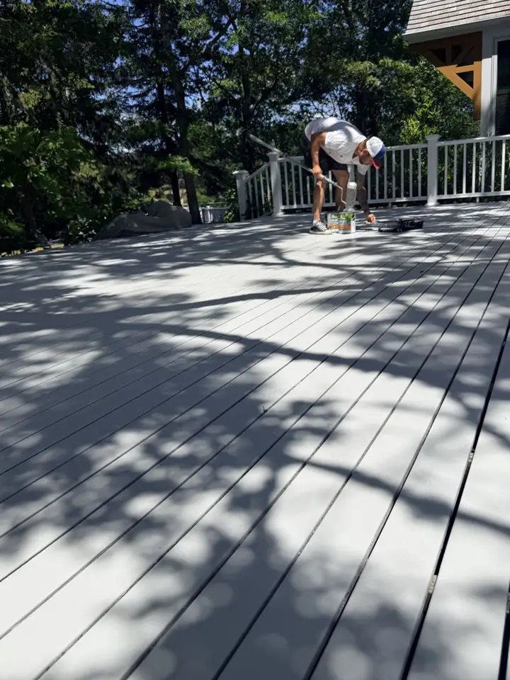 Painter working on a large deck at a Cape Cod home
