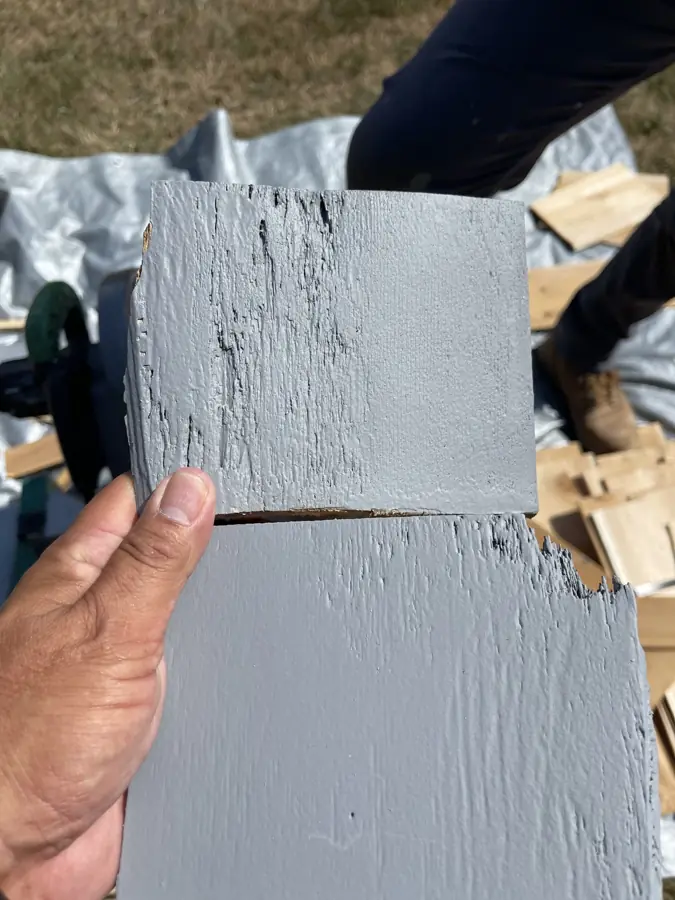 Painted wood shingle with fresh gray paint on the front